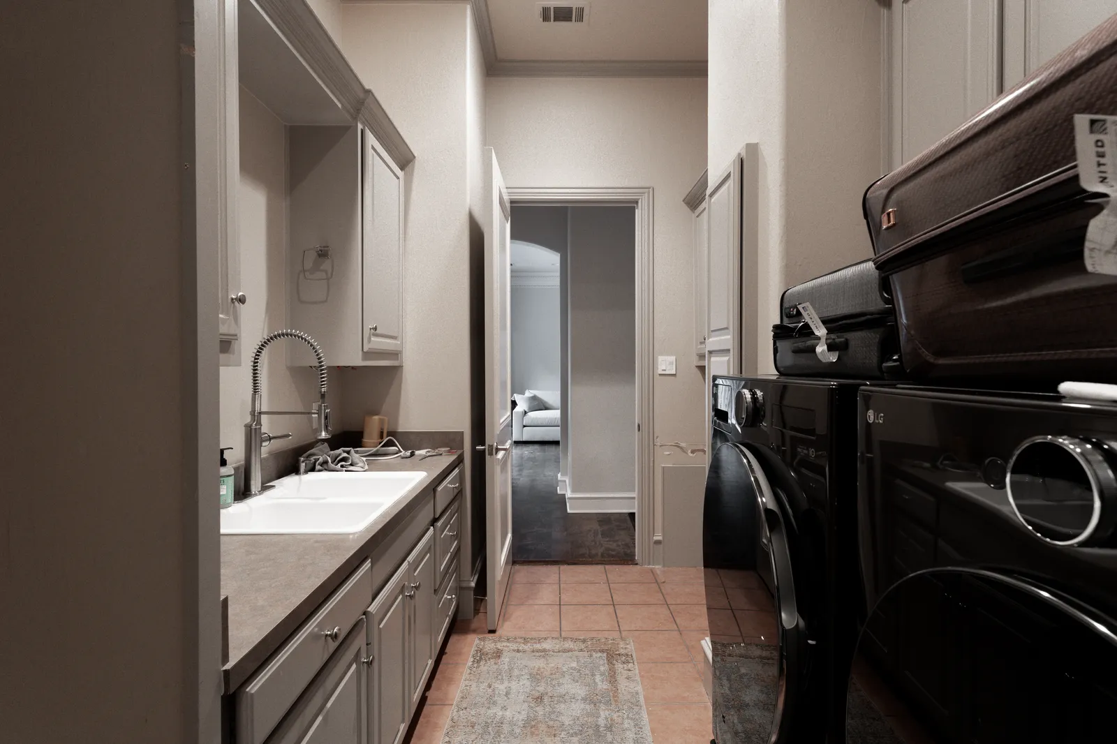 Prestwick Ln laundry room in Dallas before the renovation: gray cabinets and the original sink