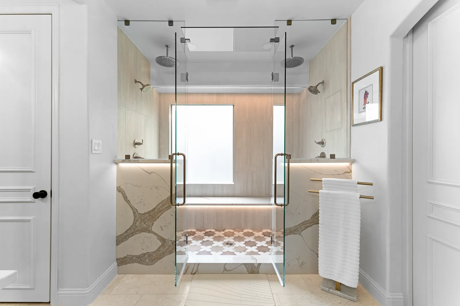 Primary bathroom at Shady Point Dr in Plano after the remodel: glass walk-in shower with dual rain heads, a built-in bench, stone slab walls, and a mosaic tile floor