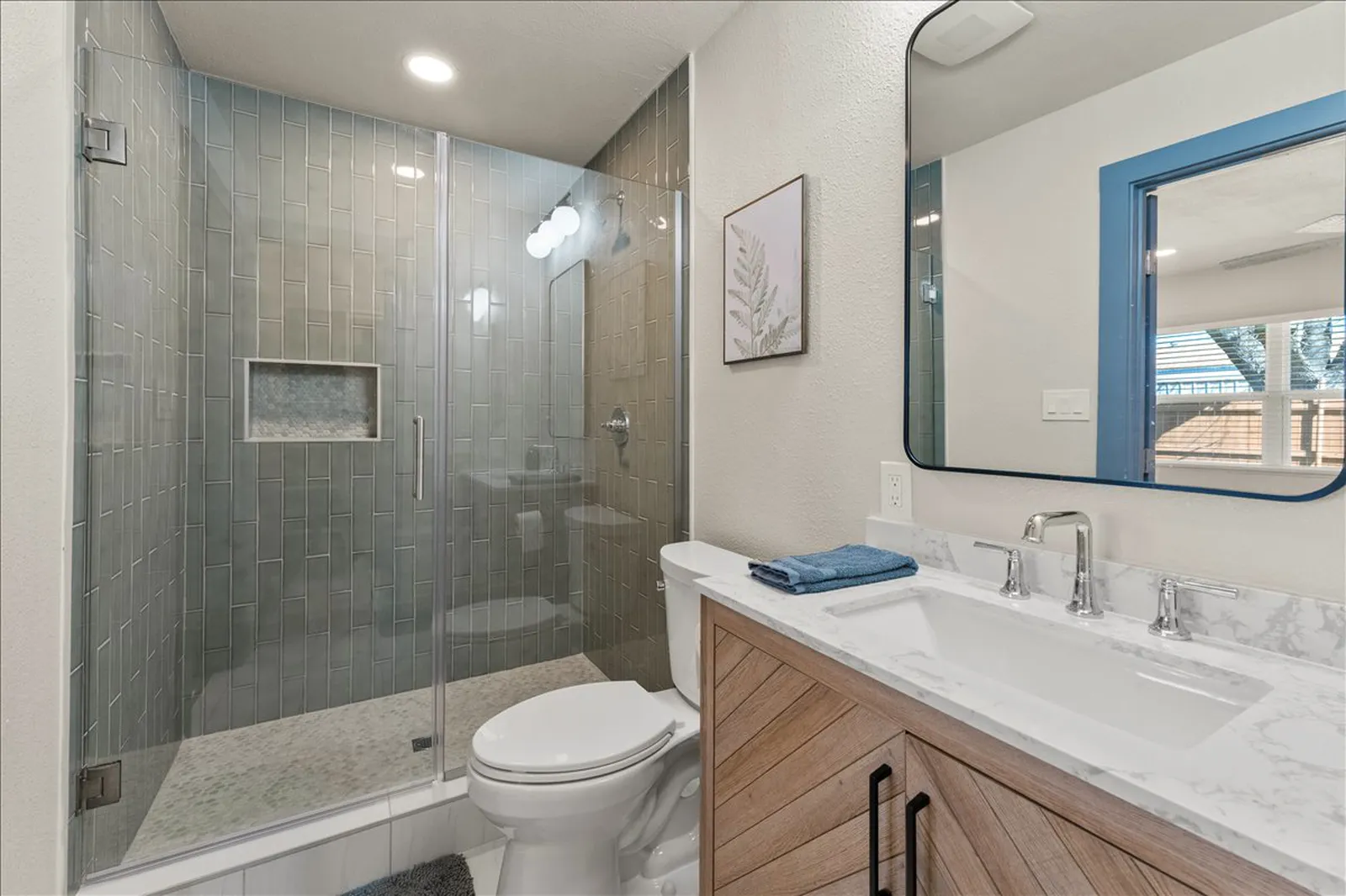 Primary bath with a tile shower and wood vanity at Sherman St. in Melissa